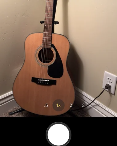 The Trast camera pointed at an acoustic guitar leaning in the corner of a room, ready to capture
